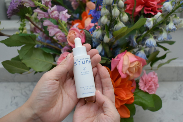 Allure contributing commerce writer Christa Joanna Lee holding the Dr. Barbara Sturms The Peptide Serum